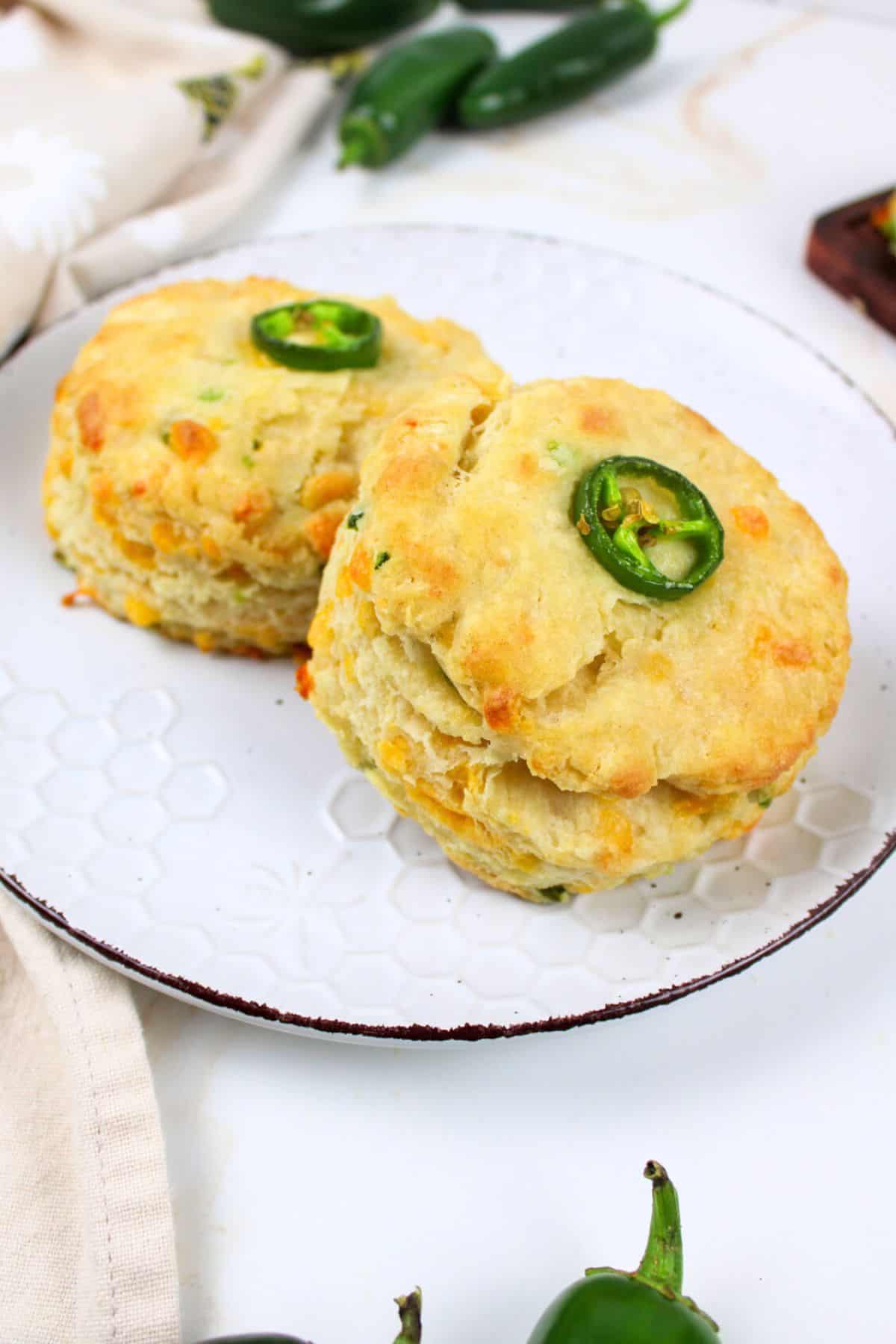 two jalapeno cheddar biscuits on a plate.