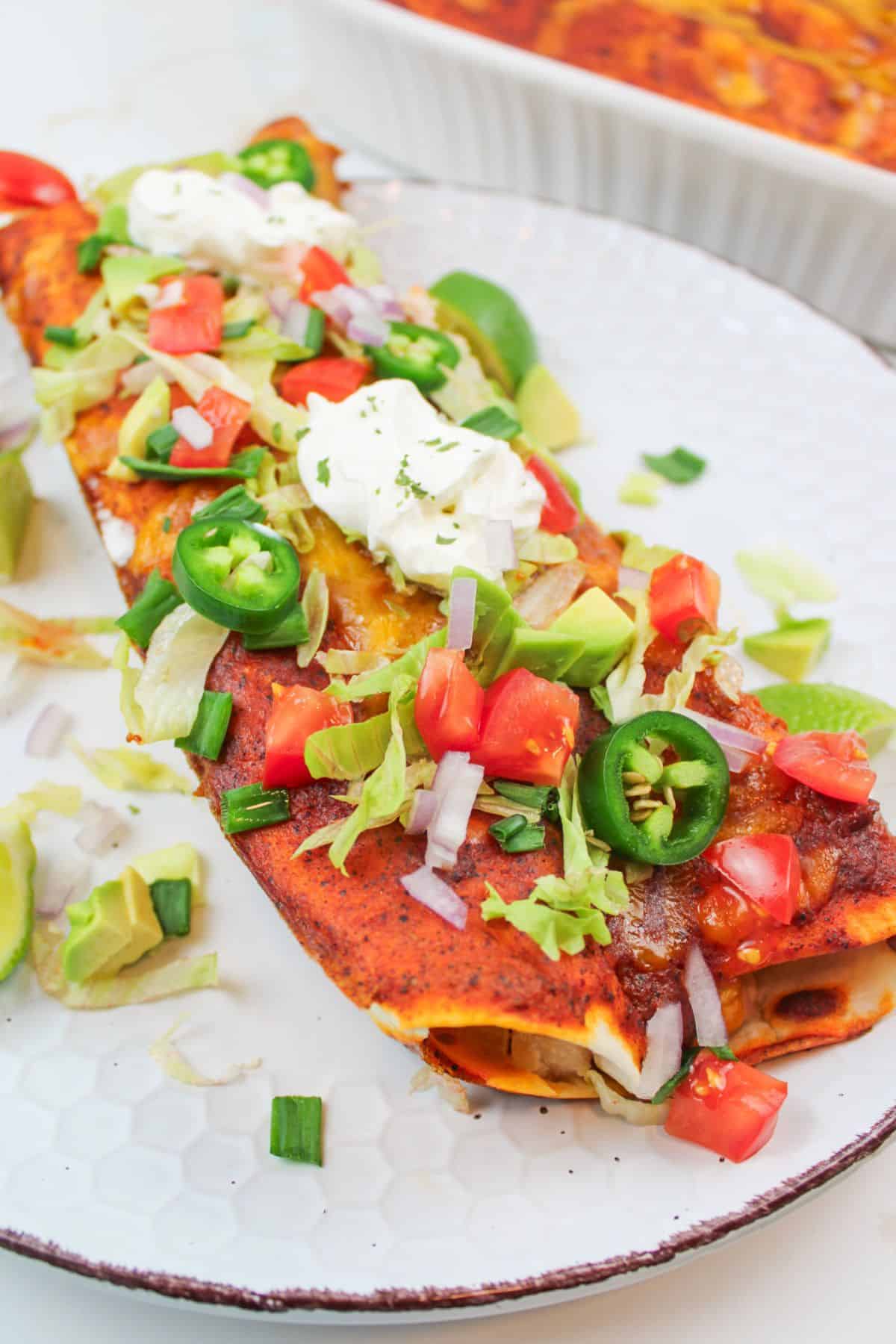 turkey enchiladas on a plate with toppings.