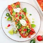 turkey enchiladas on a palte with toppings.