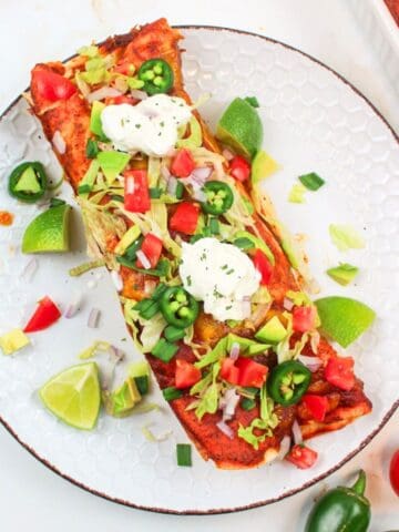 turkey enchiladas on a palte with toppings.