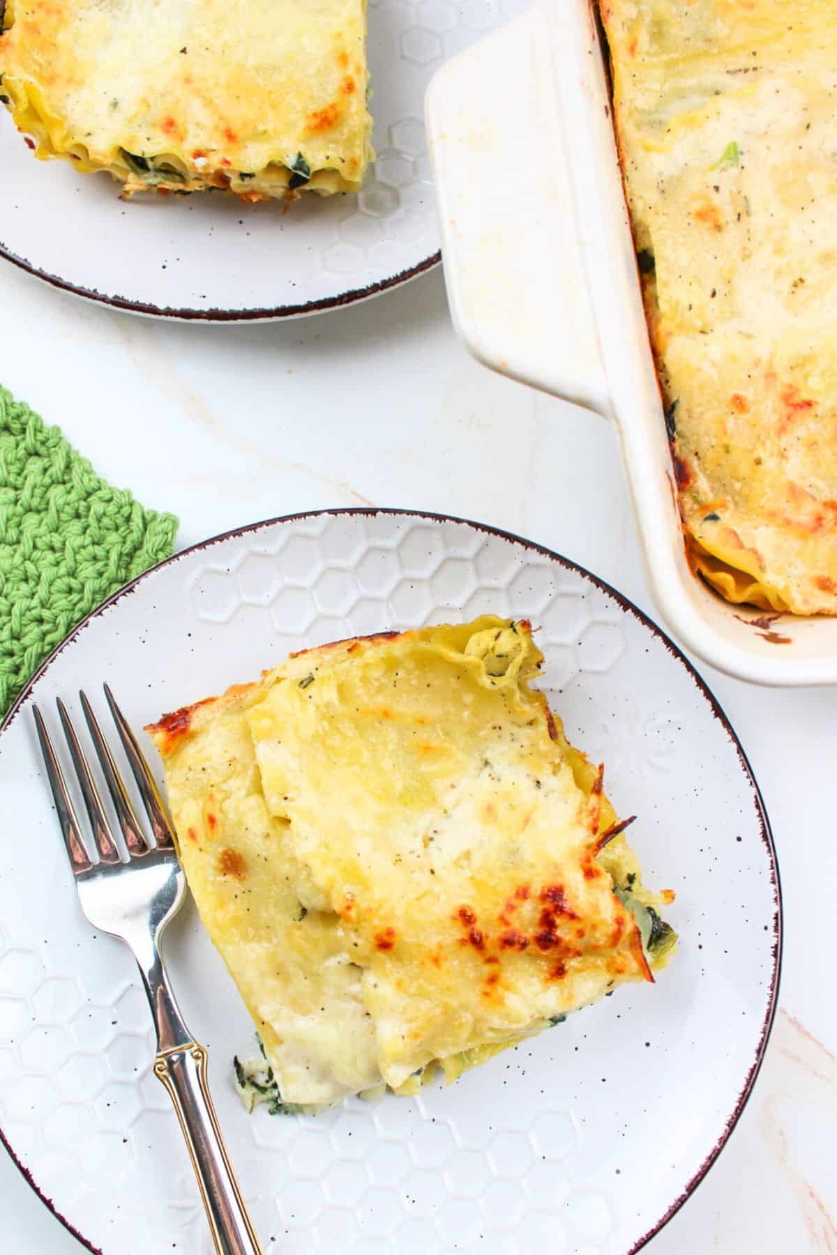 sliced servings of turkey lasagna on plates with a fork.