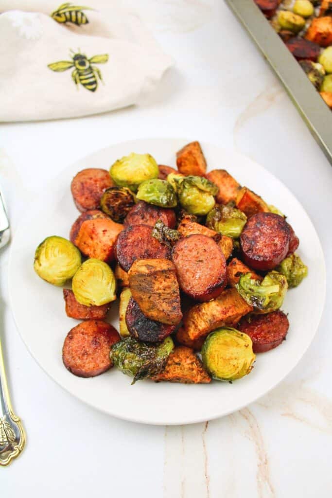 a plate filled with sausage and brussels sprout dinner.