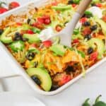 serving spoon digging into casserole dish of walking taco casserole.
