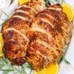 sliced cajun turkey breasts on a plate with garnishes.