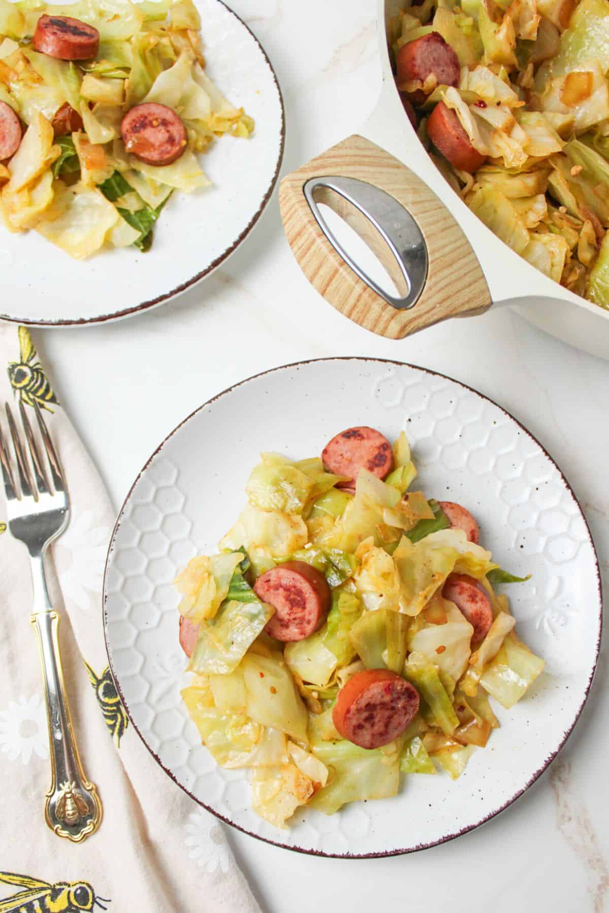 plates filled with fried cabbage and sausage.