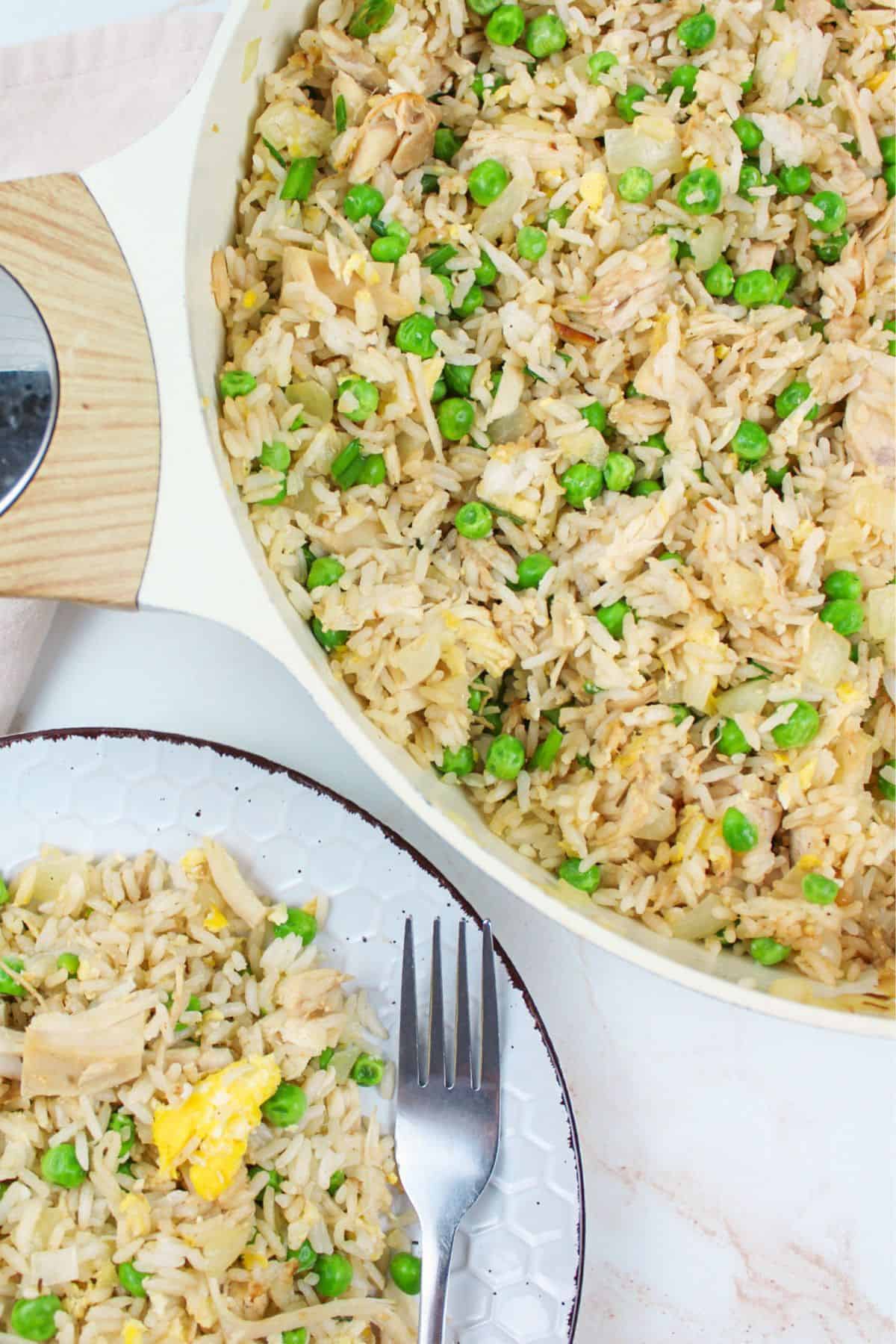turkey fried rice in a pan and on a plate with a fork.