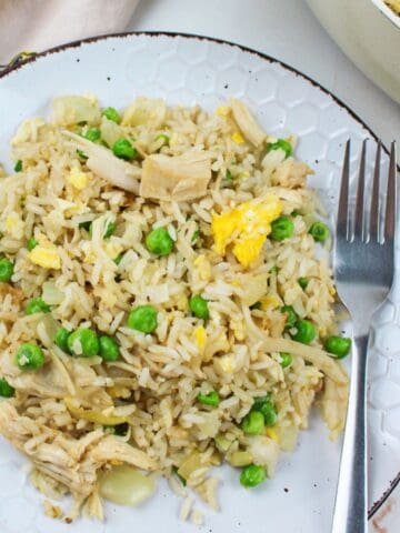 leftover turkey fried rice on a plate with a fork.