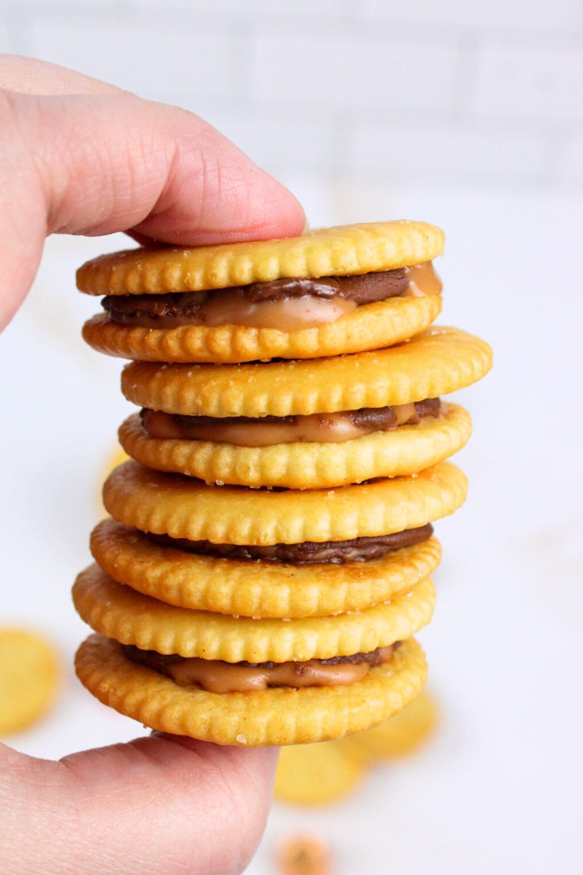 hand holding stack of rolo stuffed ritz crackers.