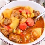 spoon full of beef stew in a bowl.